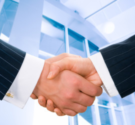 Image of businesspeople handshake on the background of office building